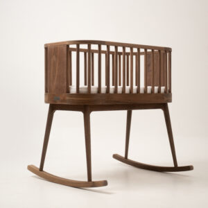 Drewniana kołyska z poprzeczkami, widok z boku, na białym tle.